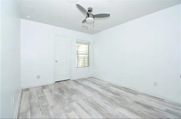 an empty room with a window and a ceiling fan