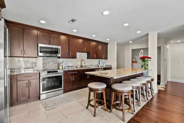 a kitchen with stainless steel appliances granite countertop a stove a sink a refrigerator and cabinets