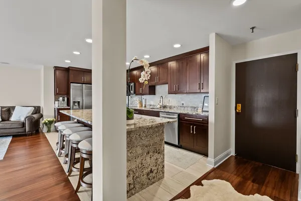 a kitchen with stainless steel appliances granite countertop a refrigerator and a stove top oven