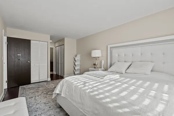 a bedroom with a large bed and a chandelier