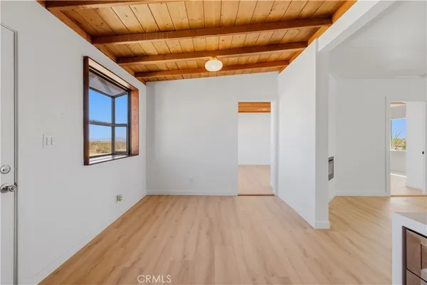 a view of a livingroom with wooden floor and windows