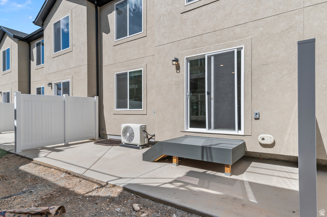 1907 East 640th North, Unit 1225 Salem, UT 84653 - Photo 14 of 20 Private patio area with concrete flooring, white privacy fencing, and a gray-finished entry platform