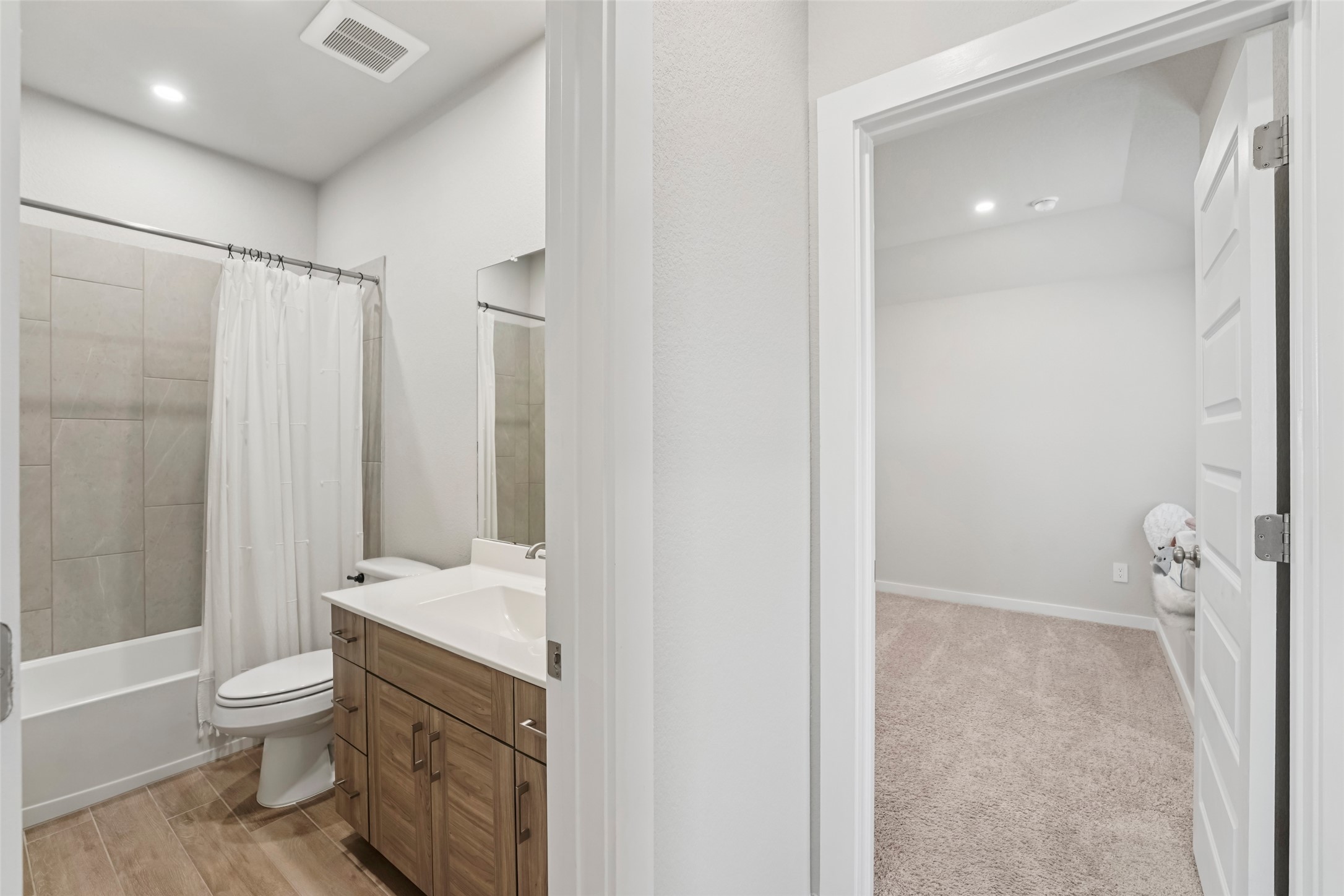 1108 Sweetspire Street Leander, TX 78641 - Photo 26 of 39 Bathroom with vanity, shower / bath combination with curtain, recessed lighting, and wood finished floors