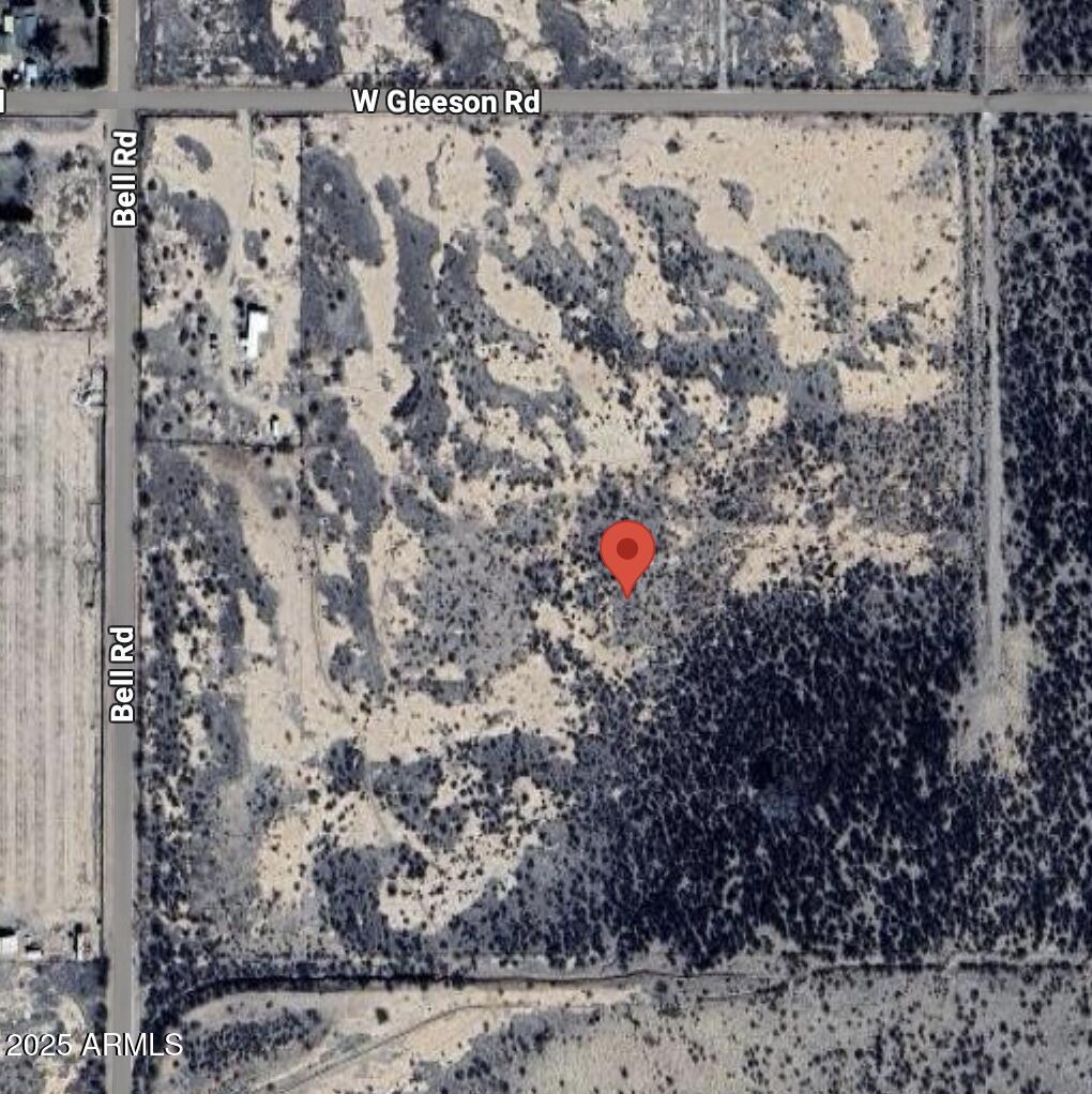 a view of a dry yard with wooden fence