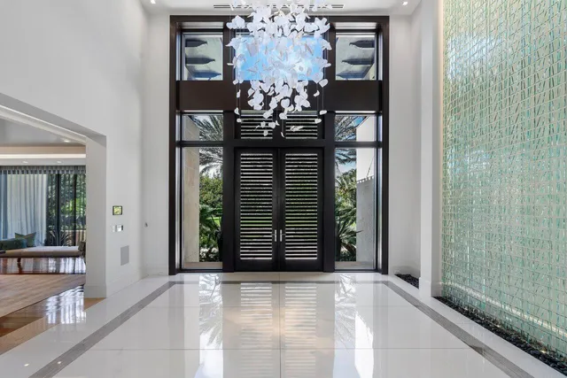 a living room with furniture and a dining table next to a large window