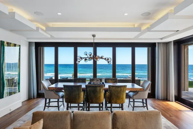 a view of a big house with a big yard and potted plants and large trees