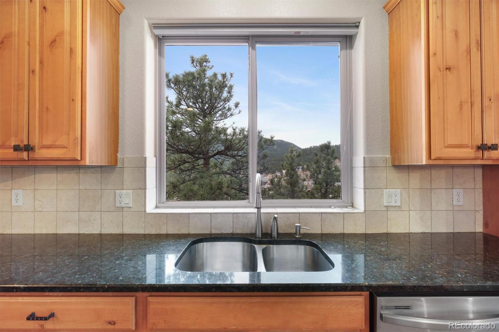 3191 Bittersweet Lane Evergreen, CO 80439 - Photo 12 of 50 a kitchen with granite countertop a sink and a window
