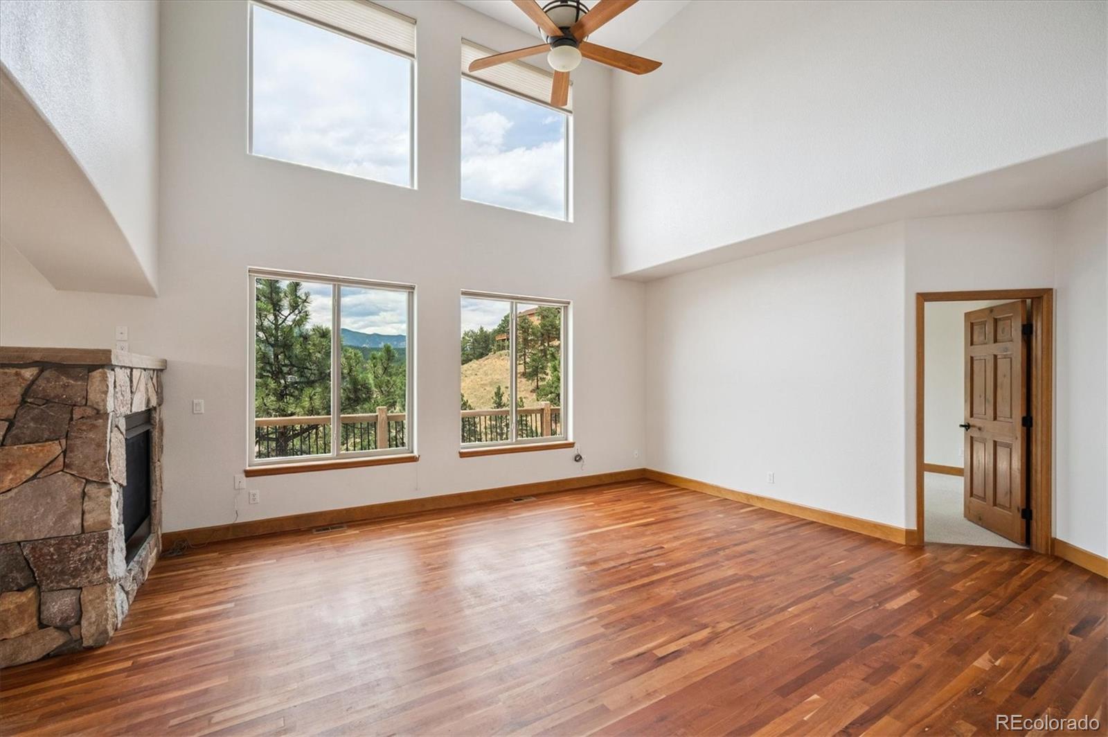 3191 Bittersweet Lane Evergreen, CO 80439 - Photo 13 of 50 a view of an empty room with a window and wooden floor