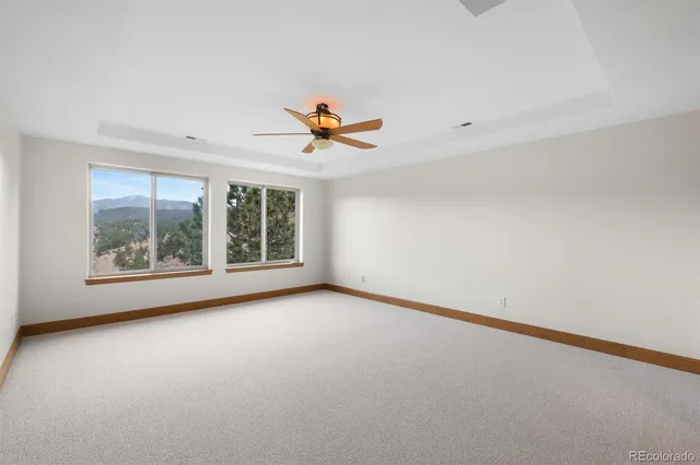 an empty room with a window and a ceiling fan