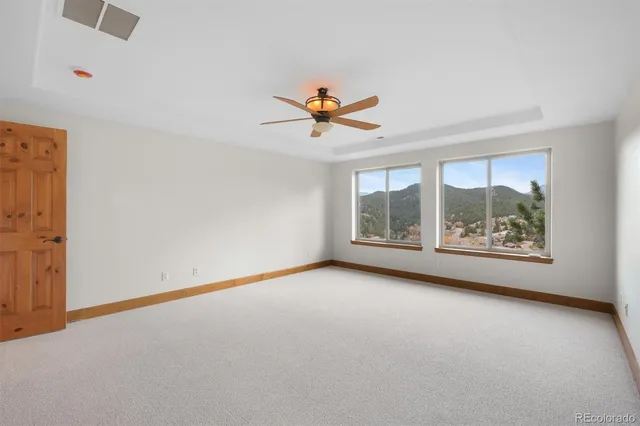 an empty room with a window and a ceiling fan