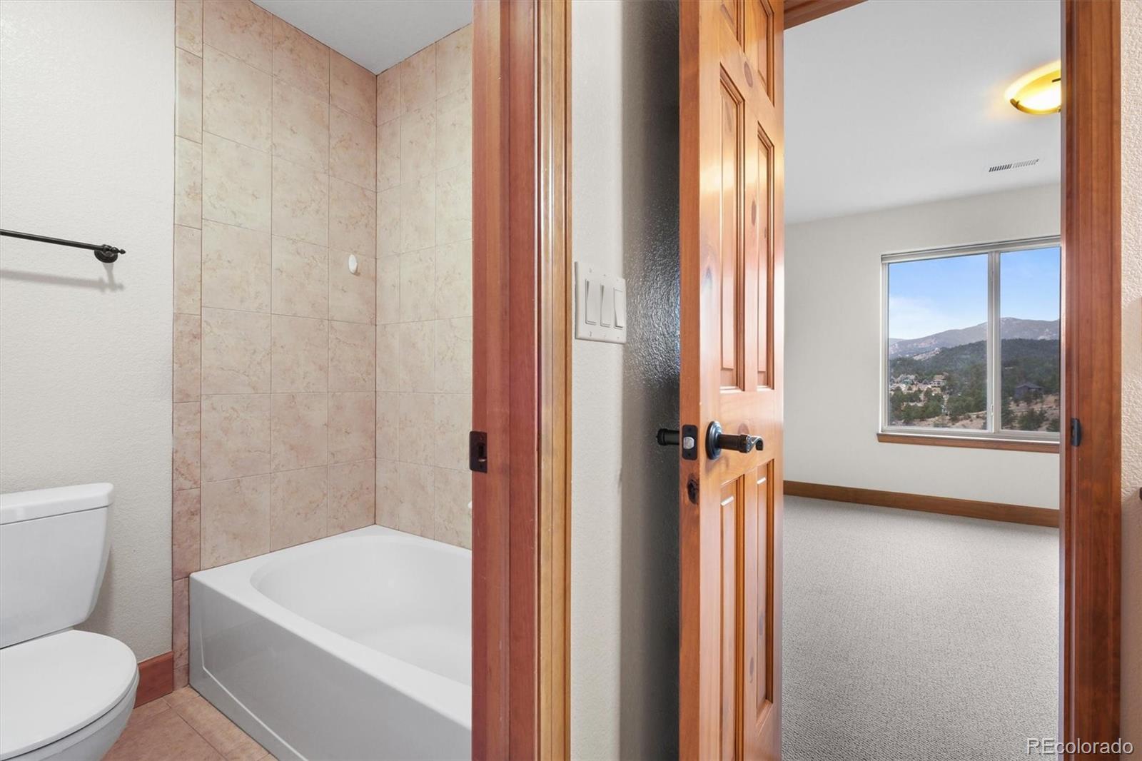 3191 Bittersweet Lane Evergreen, CO 80439 - Photo 27 of 50 a bathroom with a toilet a sink and tub