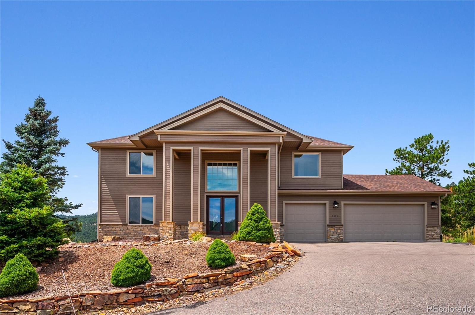 3191 Bittersweet Lane Evergreen, CO 80439 - Photo 3 of 50 a front view of a house with a yard and garage