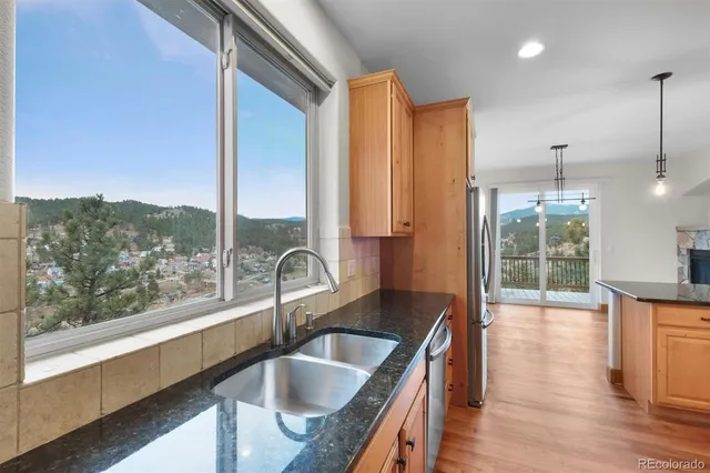 a kitchen with kitchen island granite countertop a sink and a large window
