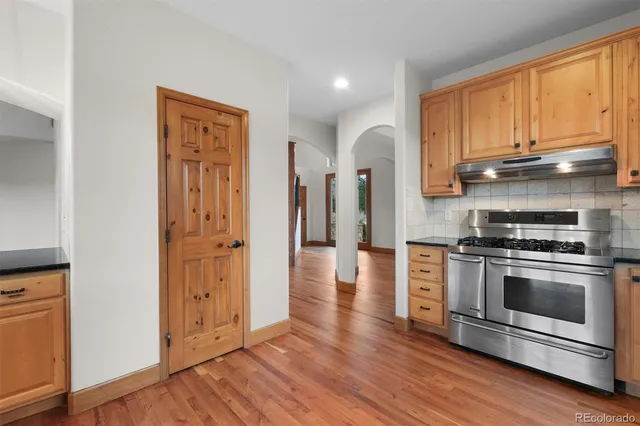 a kitchen with stainless steel appliances a stove a sink and a window