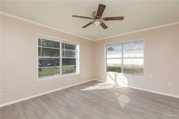 an empty room with wooden floor and windows