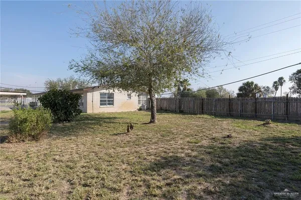 a backyard of a house with barbeque oven table and chairs