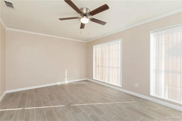an empty room with ceiling fan and window