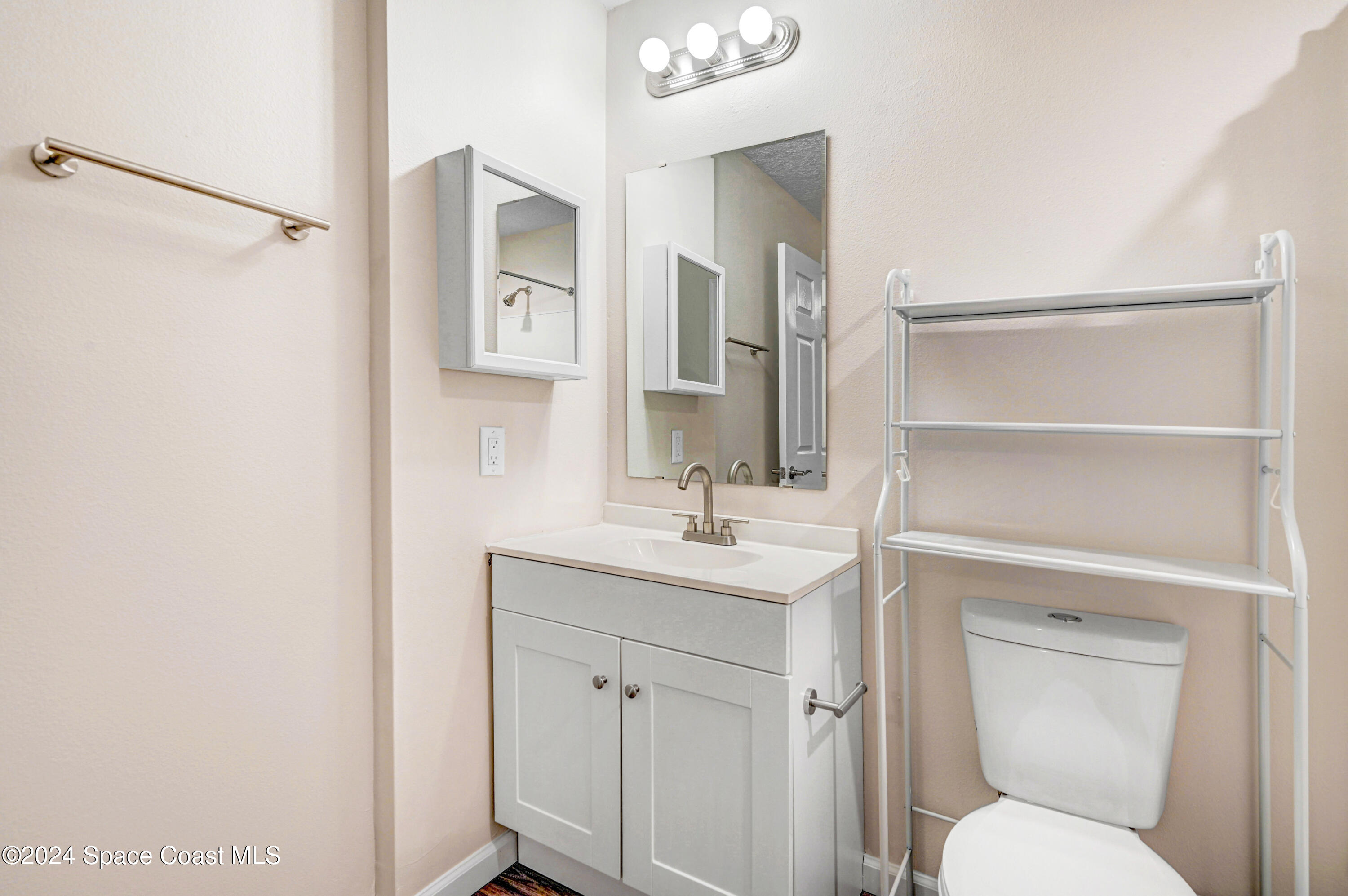 1895 Convair Street Southeast, Unit 2102 Palm Bay, FL 32909 - Photo 13 of 16 a bathroom with a toilet sink and mirror