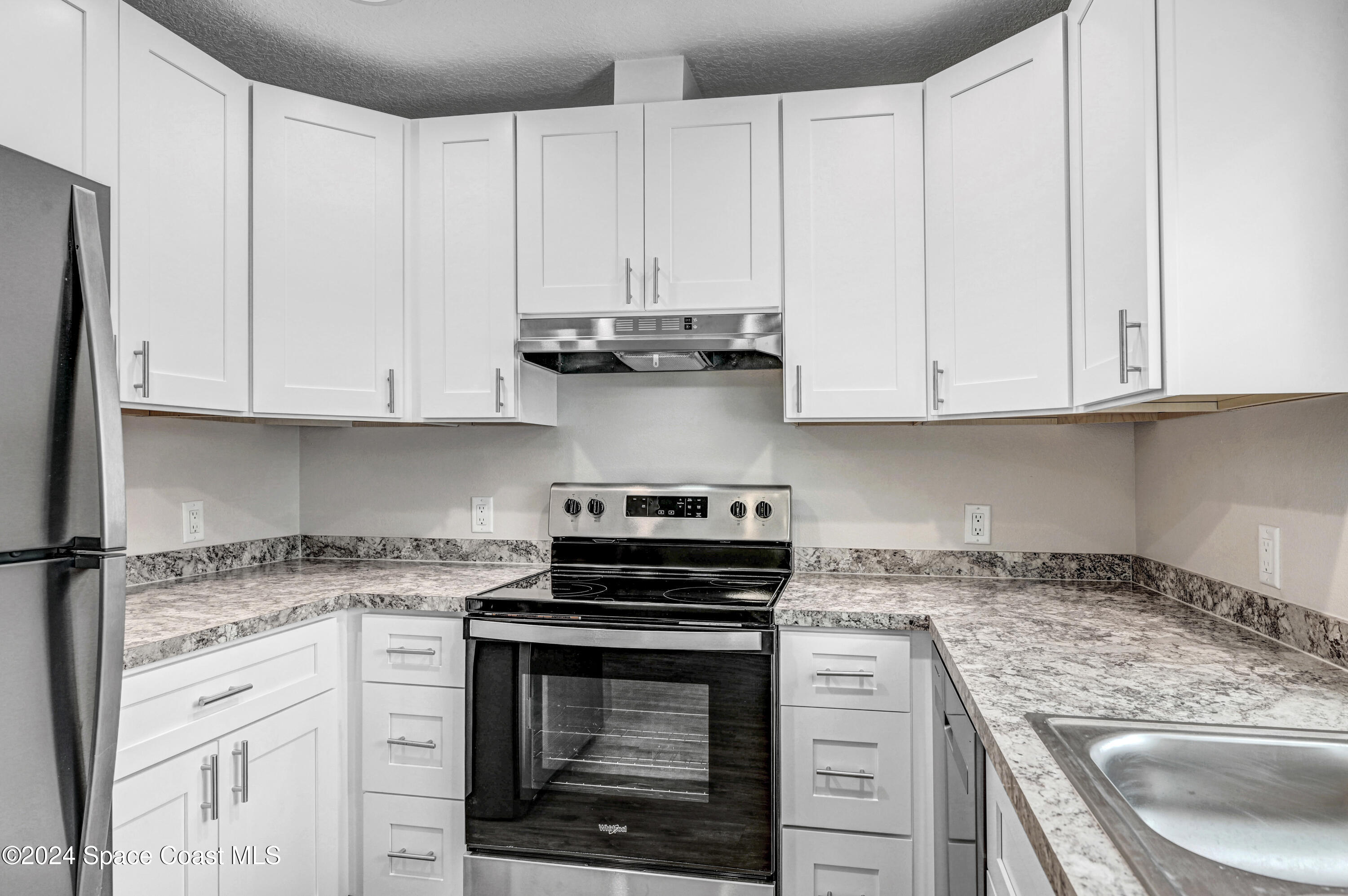 1895 Convair Street Southeast, Unit 2102 Palm Bay, FL 32909 - Photo 9 of 16 a kitchen with granite countertop white cabinets and a stove
