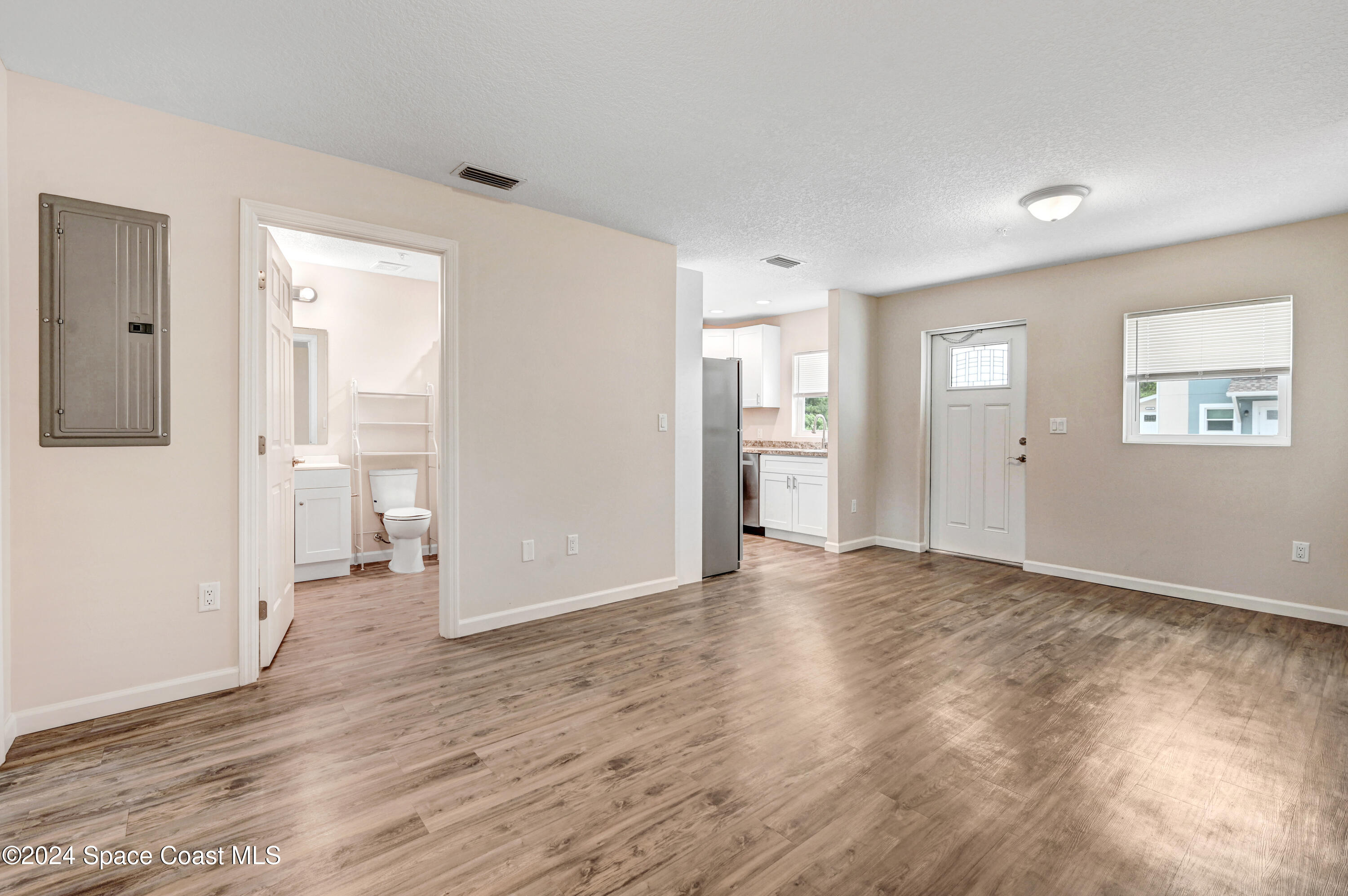 1895 Convair Street Southeast, Unit 2102 Palm Bay, FL 32909 - Photo 10 of 16 an empty room with wooden floor and windows