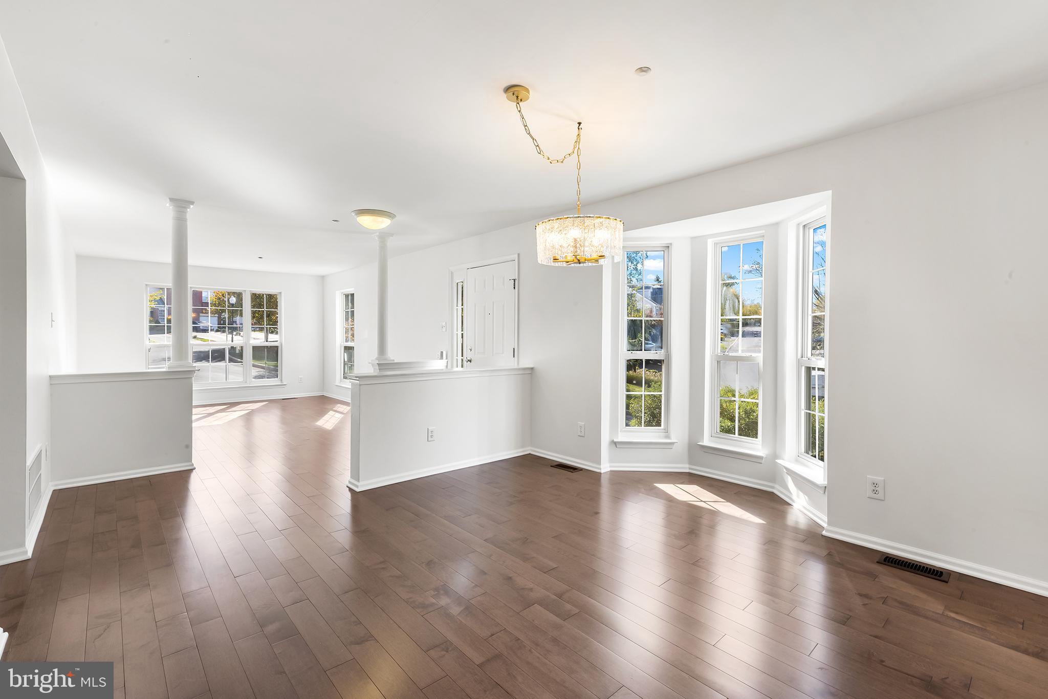 272 Militia Drive Wayne, PA 19087 - Photo 13 of 57 a view of an empty room with wooden floor and a kitchen