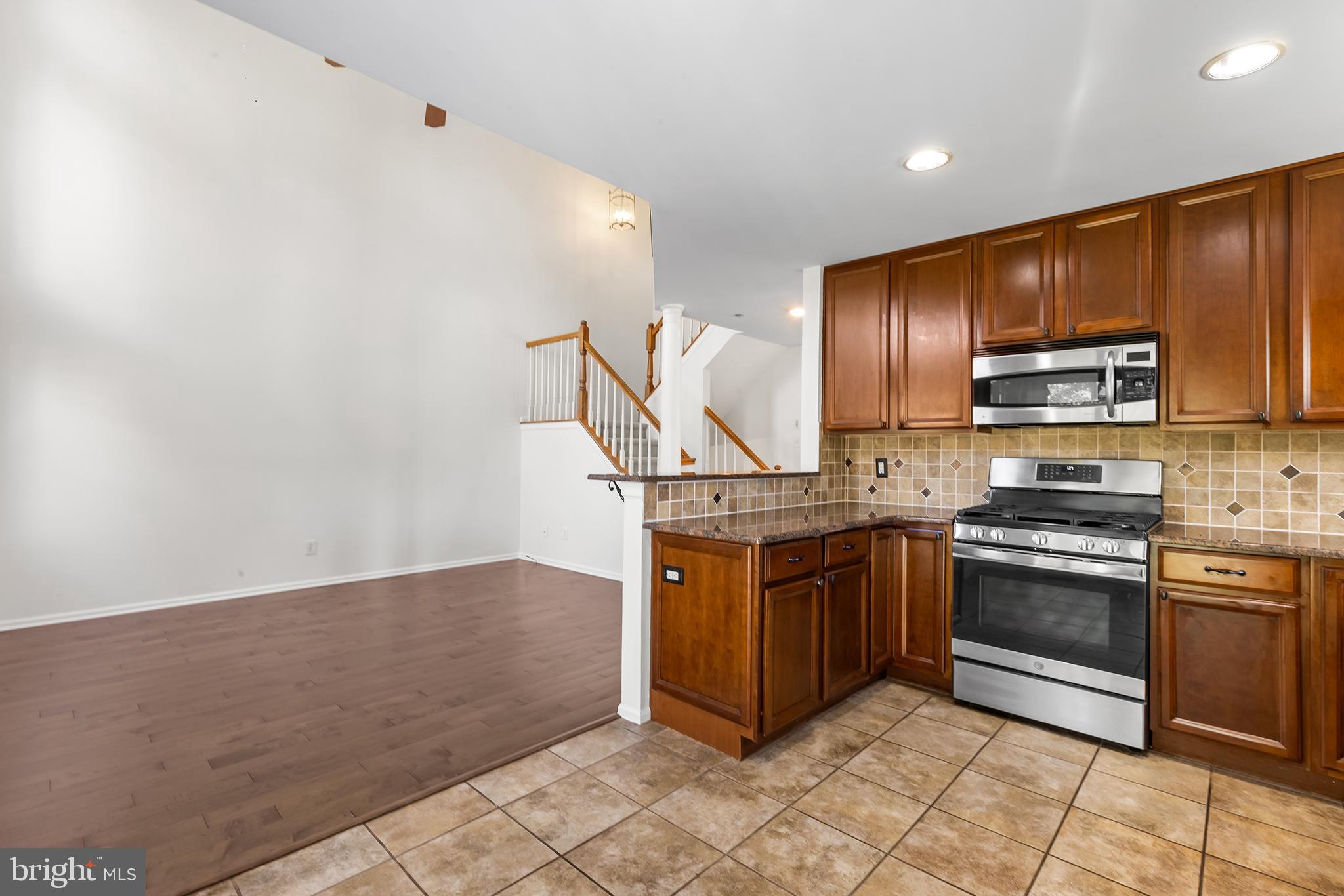 272 Militia Drive Wayne, PA 19087 - Photo 21 of 57 a kitchen with stainless steel appliances granite countertop a stove a sink and a refrigerator
