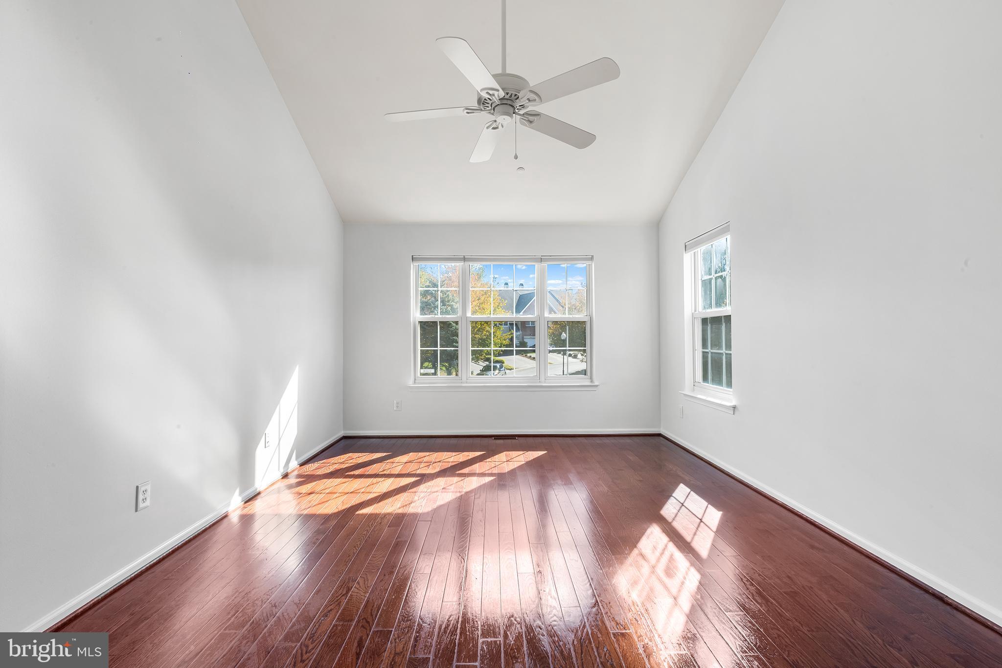 272 Militia Drive Wayne, PA 19087 - Photo 44 of 57 an empty room with wooden floor chandelier fan and windows