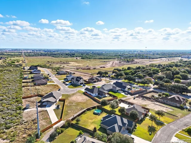 an aerial view of a city with lots of residential buildings and ocean view in back