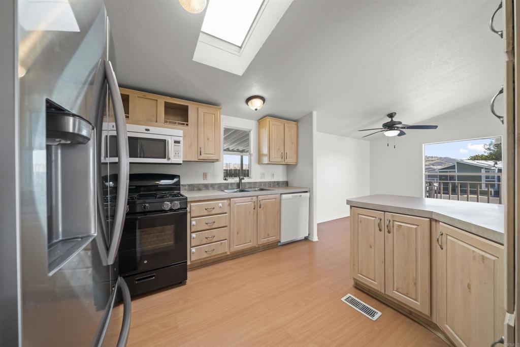 9902 Jamacha Boulevard, Unit 13 Spring Valley, CA 91977 - Photo 8 of 26 a kitchen with stainless steel appliances granite countertop a refrigerator sink and stove