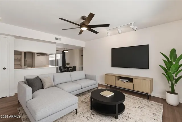 an empty room with wooden floor ceiling fan and windows