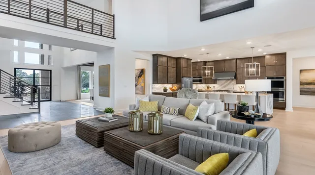 a living room with furniture kitchen view and a large window
