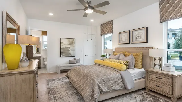 a spacious bedroom with a bed a couch and paintings on the wall