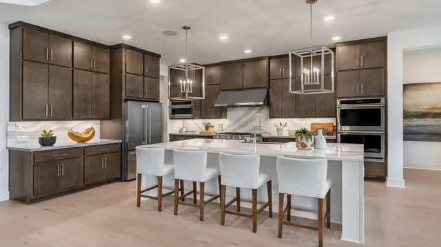 a kitchen with granite countertop a refrigerator and a stove top oven