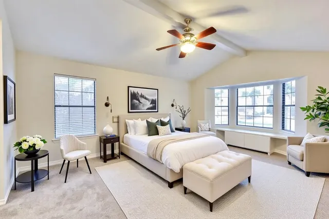 a living room with a bed furniture chandelier and a window