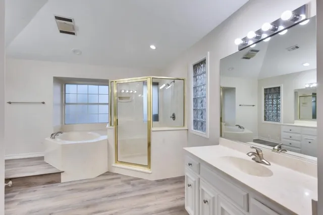 a bathroom with a sink a toilet a mirror and shower