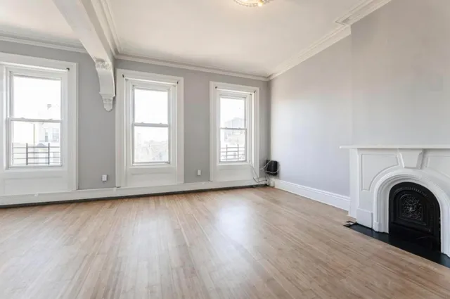 an empty room with wooden floor and window