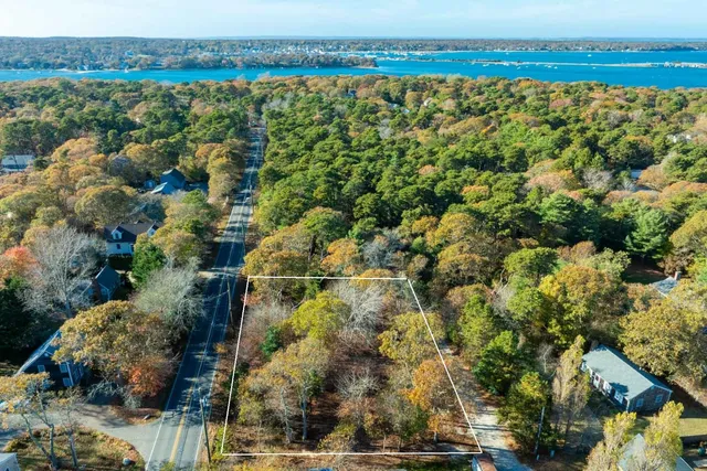 an aerial view of residential houses with outdoor space and trees