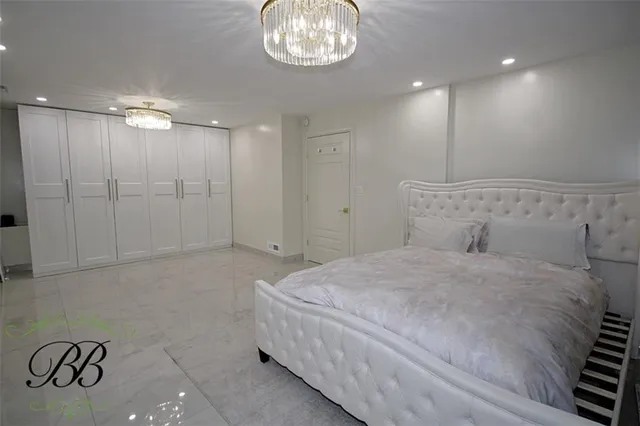 a spacious bedroom with a bed and a chandelier