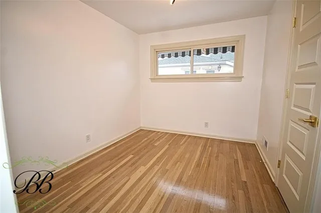 a view of a room with wooden floor and a window