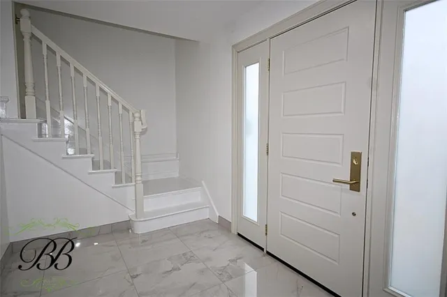 a view of entryway with stairs and white door