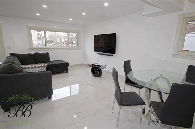 a living room with furniture a flat screen tv and a window