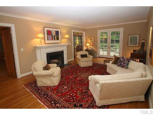 3938 Dover Road Durham, NC 27707 - Photo 3 of 11 The living room is anchored by a gorgeous fireplace. Doors to the panelled library and sunroom flank each side of the fireplace. True divided light glass French doors open to the flagstone patio and private fenced backyard