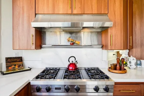 a kitchen with stove and cabinets