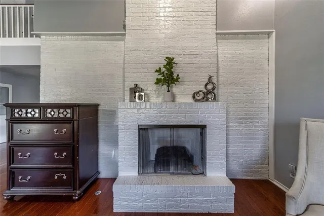 a living room with a fireplace and a potted plant