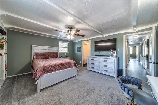 a spacious bedroom with a bed and a flat screen tv