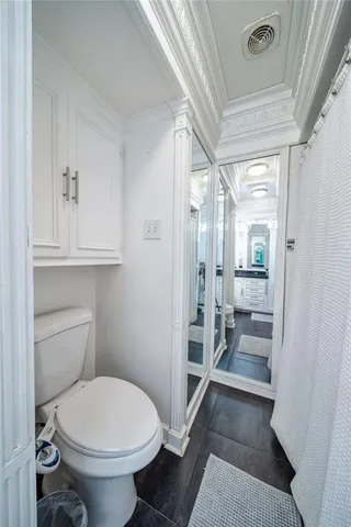 a bathroom with a toilet a sink and glass door