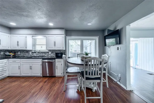 a kitchen with stainless steel appliances granite countertop wooden floors a refrigerator and a stove top oven