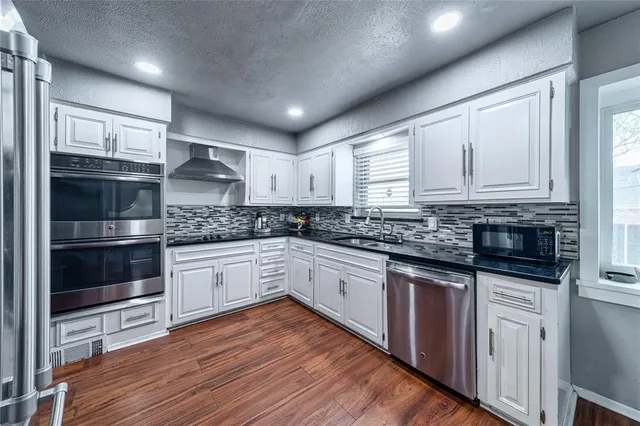 a kitchen with granite countertop wooden cabinets and white appliances