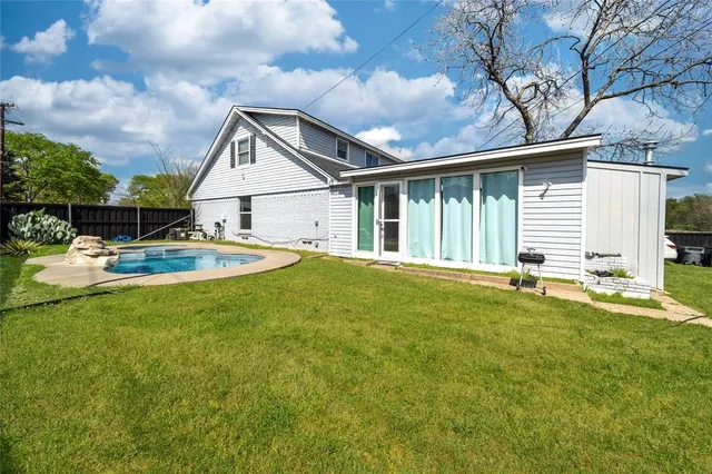 a backyard of a house with table and chairs