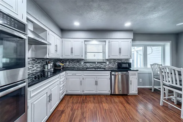 a kitchen with wooden floors and white appliances